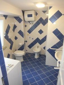a blue and white bathroom with two toilets and a sink at Villa Glicine in Ponza +28 photos