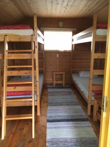 a room with three bunk beds and a window at Lomatila Ollila Bungalows in Kerimäki