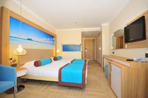 a hotel room with a bed and a flat screen tv at Blue Bay Platinum in Marmaris