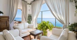 a living room with white furniture and a view of the ocean at Hotel Marincanto in Positano