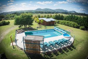 an overhead view of a swimming pool with chairs and a building at Cabañas Luna Lunera in Tandil