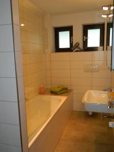 ein Badezimmer mit einer Badewanne und einem Waschbecken in der Unterkunft Messewohnung Sehnde in Sehnde