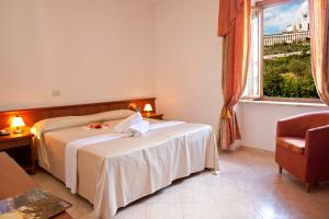 um quarto de hotel com duas camas e uma janela em Assisi Garden em Assis