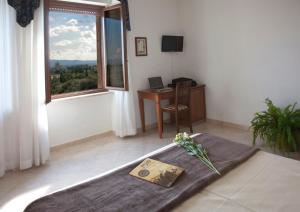 um quarto com uma cama, uma secretária e uma janela em Assisi Garden em Assis