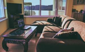a living room with a couch and a table with a laptop at Lakeview-Estate ApartHotel in Staro Myasto +45 photos