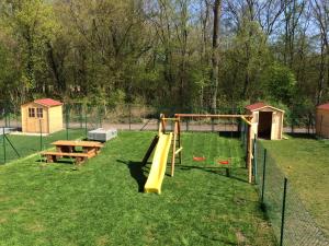 einen Spielplatz mit Rutsche im Gras in der Unterkunft Apartmány Hlohovec in Hlohovec