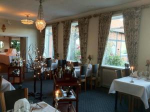 a dining room with tables and chairs and windows at Sallingsund Færgekro in Nykøbing Mors