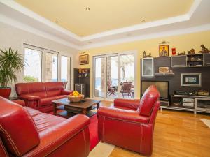 a living room with red leather chairs and a table at Villa Royal Dream in Sveti Stefan