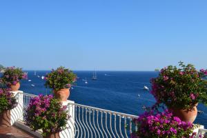 a balcony with flower pots with the ocean in the background at Hotel Marincanto in Positano