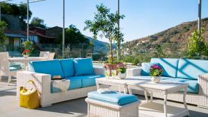 a patio with blue and white chairs and tables at Casale Panayiotis in Kalopanayiotis