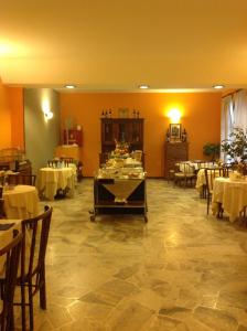 a dining room with white tables and chairs at Aer Hotel Malpensa in Oleggio