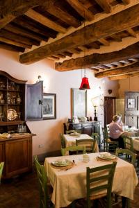 Antica Dimora Leones في بالايا: مطعم بطاولات وكراسي وشخص في الخلفية