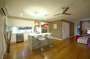 a kitchen with a counter and two stools at Reiki Spectacular House in Gold Coast