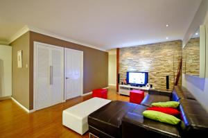a living room with a leather couch and a tv at Reiki Spectacular House in Gold Coast