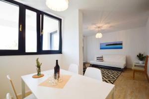 a white dining room with a white table and chairs at Leut Apartment, 3min beach, 15min center in Pula