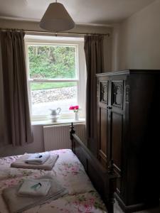 ミラーズ・デールにあるAnglers restのベッドルーム1室(ドレッサー付きのベッド1台、窓付)