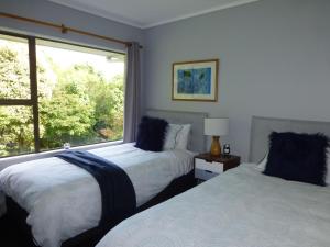 um quarto com 2 camas e uma grande janela em Tranquil Private Rural Retreat em Tauranga