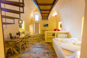 a room with two beds and a table and a dining room at Alma Libre Suites in Fira +57 photos