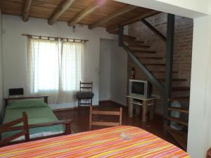 una camera da letto con scala e un soggiorno di Cabañas La Barranquita a Potrero de los Funes
