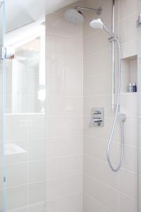 um chuveiro com uma porta de vidro na casa de banho em Das ELBCOTTAGE em Hamburgo