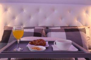 a tray with a glass of orange juice and a plate of food and a cup at Monte & Paradiso in Pula