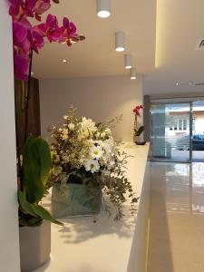 a white vase filled with flowers sitting on a counter at Hotel Perla in Benidorm