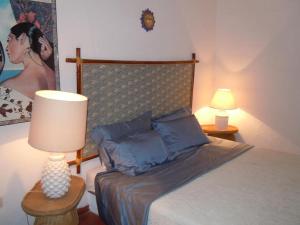 サンタ・マルゲリータ・ディ・プーラにあるMaison Nóusのベッドルーム1室(ランプと絵画付)