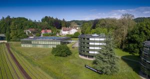 eine Luftansicht eines Gebäudes mit einem Feld und Bäumen in der Unterkunft Centre Loewenberg in Murten