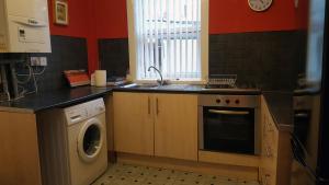 a kitchen with a sink and a washing machine at Blackpoolholidaylets Charles Street in Blackpool