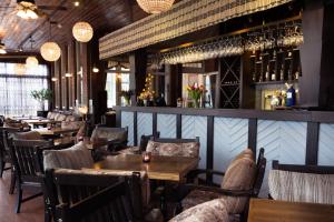 a restaurant with tables and chairs and a bar at Hotel Villa Wesset in Pärnu