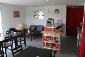 Le Champ De La Ferme في Saint-Gervais en-Belin: مطبخ وغرفة معيشة مع طاولة وكراسي