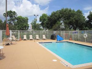 uma piscina com cadeiras e uma cerca em Extended Stay America Suites - Fort Lauderdale - Cypress Creek - NW 6th Way em Fort Lauderdale