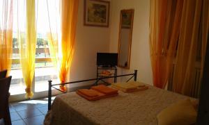 マルシリアナにあるLa Villaのベッドルーム1室(オレンジ色のカーテンと窓付きのベッド1台付)
