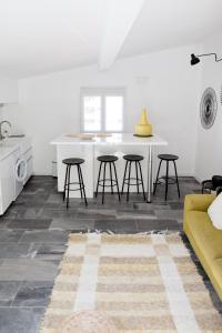 uma cozinha e sala de estar com uma mesa e bancos em L'Orangeraie et la Palmeraie d'Endoume em Marselha