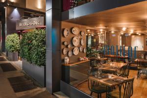 un restaurante con mesas, sillas y platos en la pared en Windsor Hotel Milano, en Milán