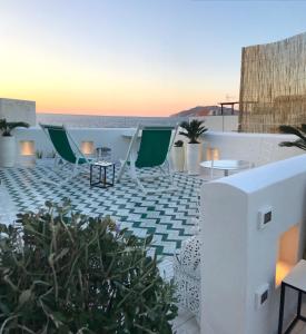 eine Dachterrasse mit Stühlen, Tischen und Meerblick in der Unterkunft Casa Sultana in Favignana