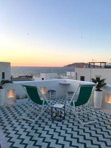 eine Terrasse mit 2 Stühlen, einem Tisch und Meerblick in der Unterkunft Casa Sultana in Favignana