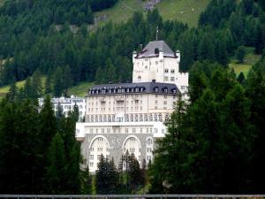 Schloss Hotel & Spa Pontresina في بونتريسنا: مبنى ابيض كبير فوق جبل