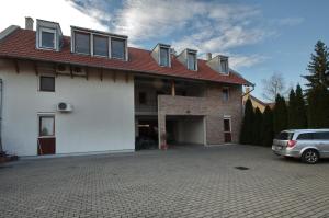 a house with a car parked in front of it at Bíbor Apartman in Gyula