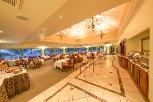 a restaurant with tables and chairs in a room at Lake Kivu Serena Hotel in Gisenyi