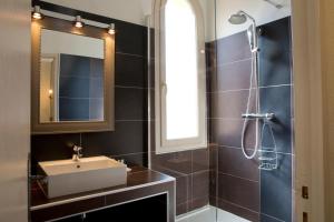 y baño con lavabo, espejo y ducha. en Le Mas des Citronniers, en Collioure