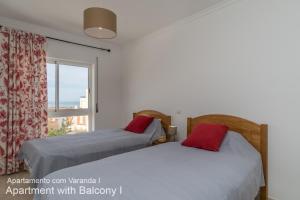 ポルティマンにあるAkisol Praia da Rocha In IIIのベッドルーム1室(ベッド2台付)、景色を望む窓が備わります。