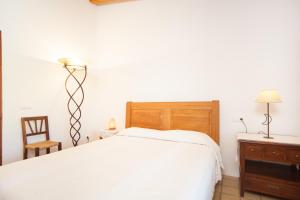 a bedroom with a bed and a lamp and a chair at Ses Planes - Adults Only ( Ca Na Faustina) in El Port de la Selva