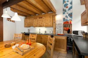 a kitchen with wooden cabinets and a wooden table at Apartment Vila 1 in Chamonix