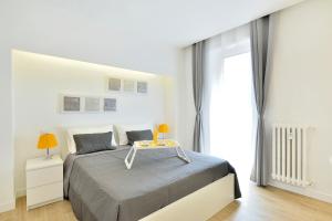 ローマにあるNew Romantic Trastevere Apartmentの白いベッドルーム(ベッド1台、テーブル付)