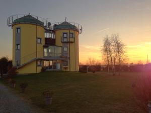 un gran edificio amarillo con una puesta de sol en el fondo en I Silos Guest house, en Seriate