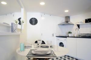 uma cozinha branca com uma mesa com pratos em Alfama Apartment Rose - Guitarra em Lisboa