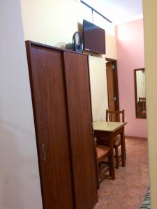 um quarto com uma divisória com uma mesa e uma televisão em Hostal El Pillkay em Trujillo