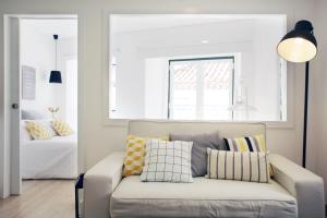 salon z kanapą z poduszkami i łóżkiem w obiekcie Alfama Rose Apartment - Elétrico w Lizbonie