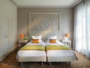 two beds in a bedroom with a headboard at Splendid Etoile in Paris